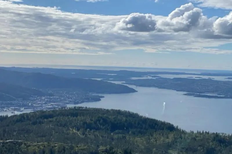 Byfjorden and the islands north of Bergen seen from a ridge, layers of blue water and headland fading into haze.